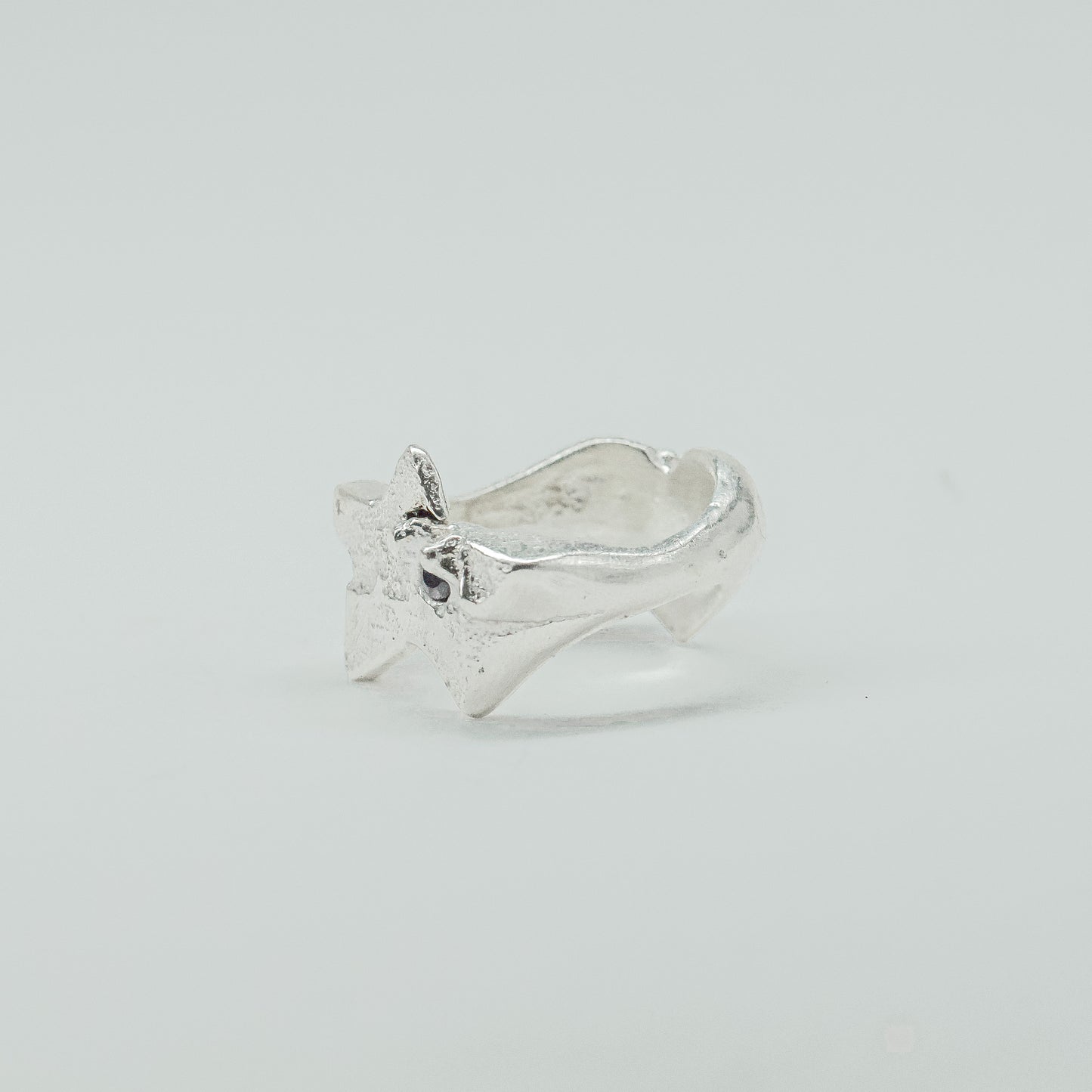 Sculptural silver ring showcasing both a heart and star form, with small gemstones set into each motif. Handmade and one of a kind.