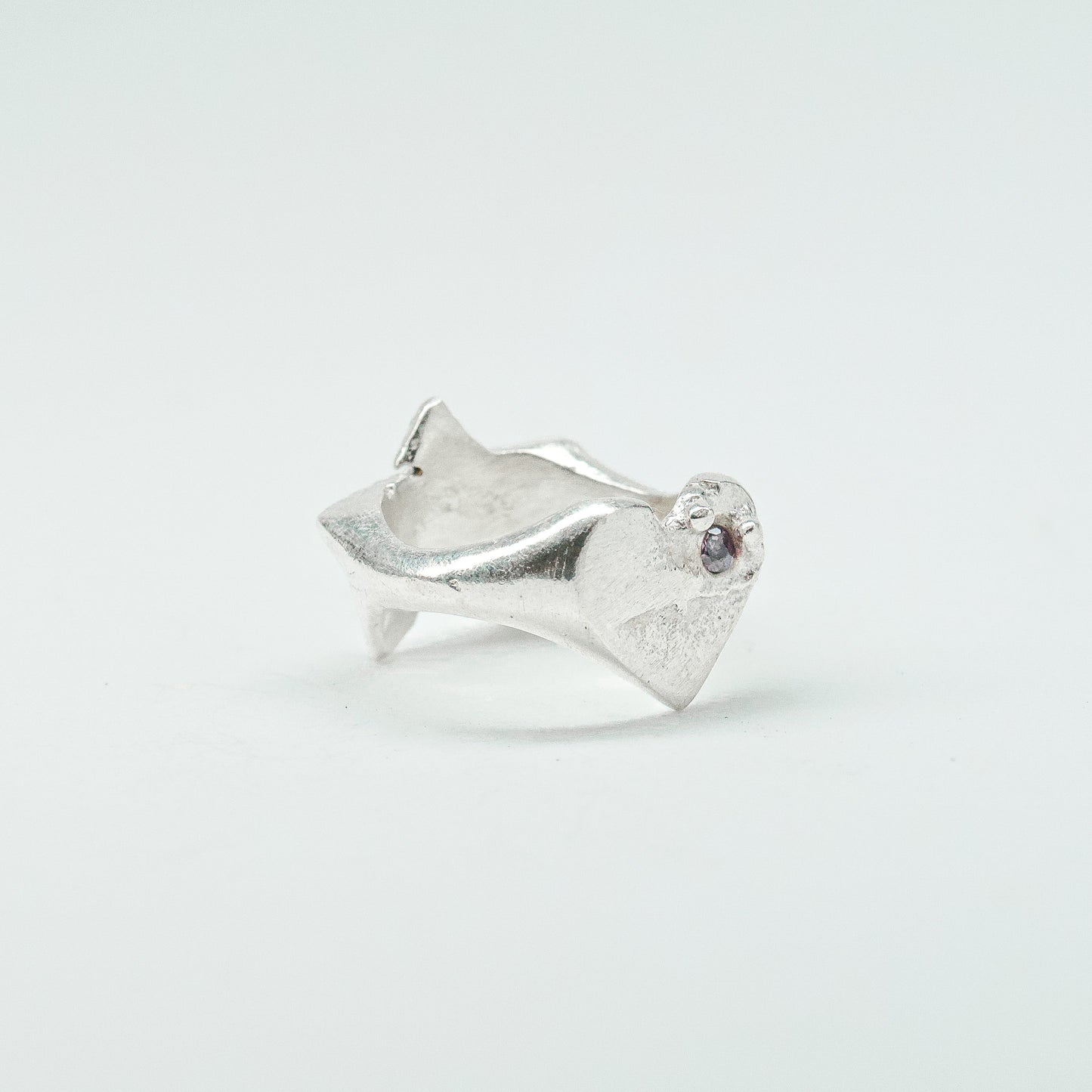 Sculptural silver ring showcasing both a heart and star form, with small gemstones set into each motif. Handmade and one of a kind.