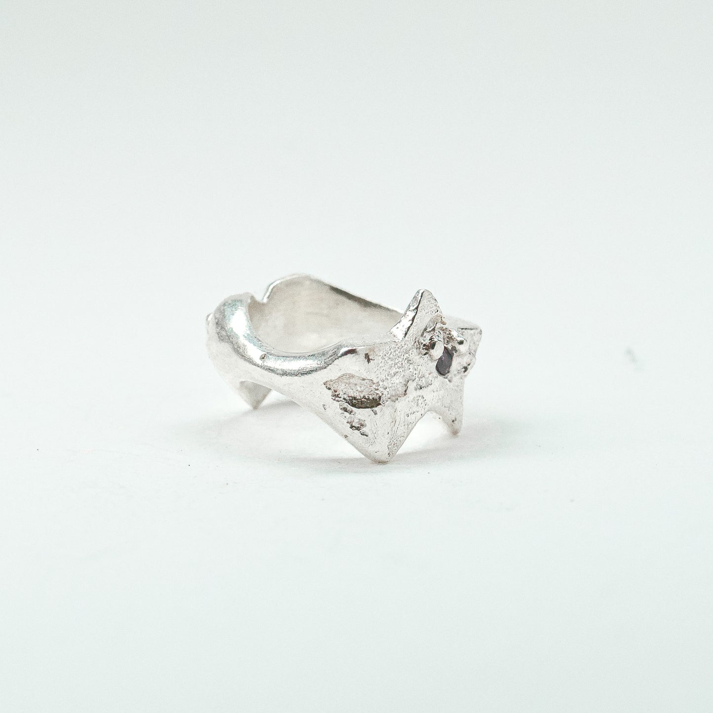 Sculptural silver ring showcasing both a heart and star form, with small gemstones set into each motif. Handmade and one of a kind.