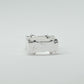 Hand-sculpted sterling silver ring with a bold, square silhouette and deep textured finish, featuring small round gemstones set into each corner.