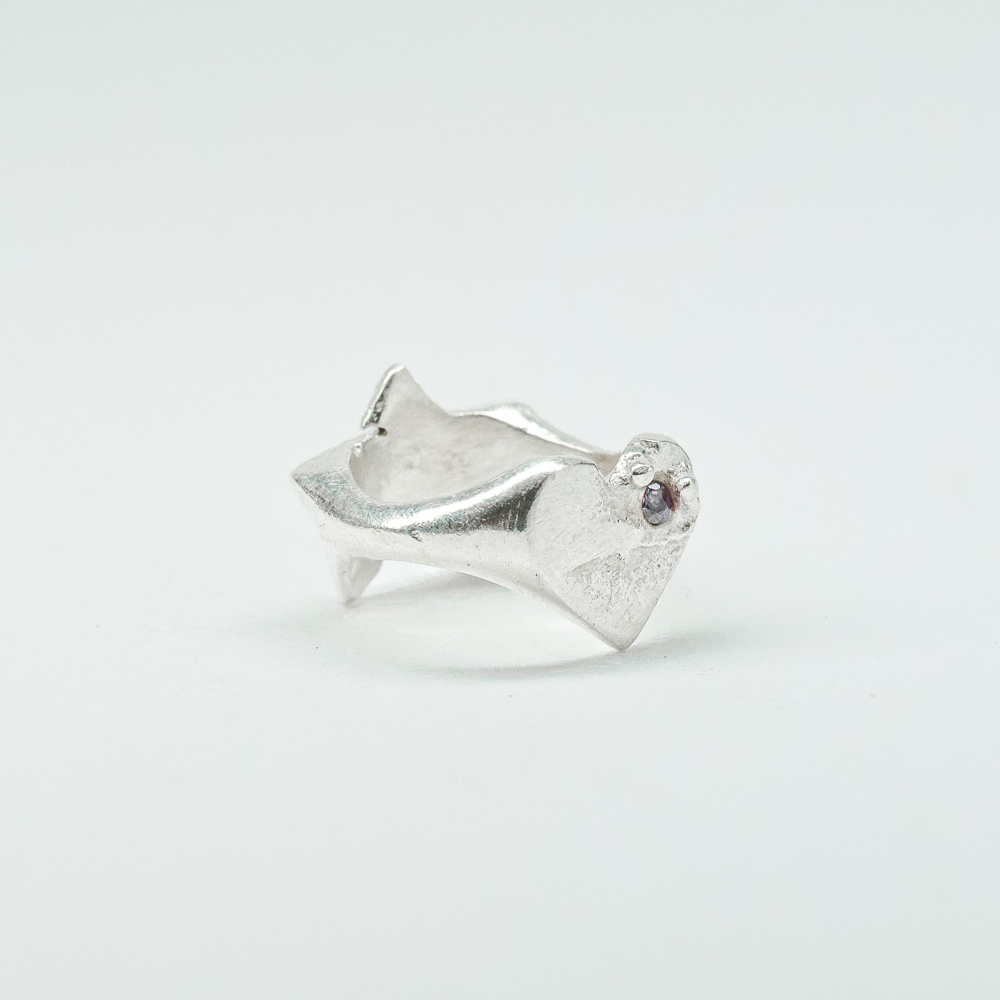 Sculptural silver ring showcasing both a heart and star form, with small gemstones set into each motif. Handmade and one of a kind.