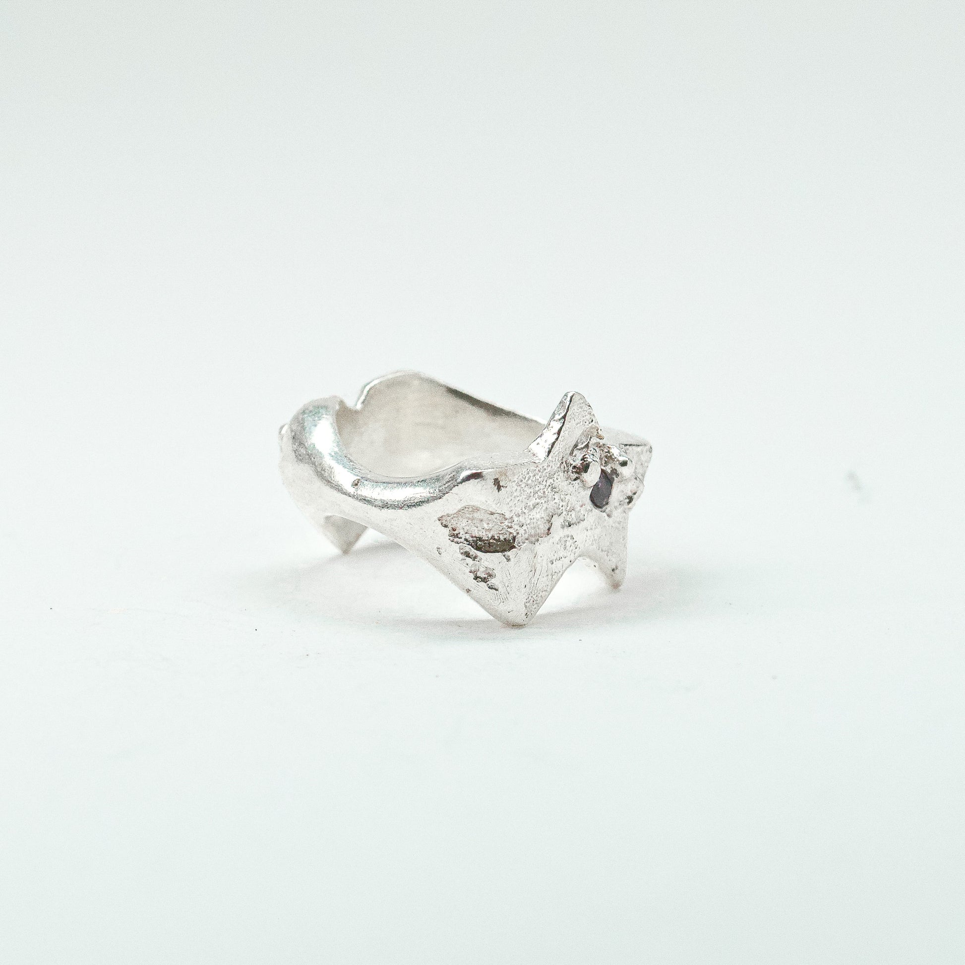 Sculptural silver ring showcasing both a heart and star form, with small gemstones set into each motif. Handmade and one of a kind.