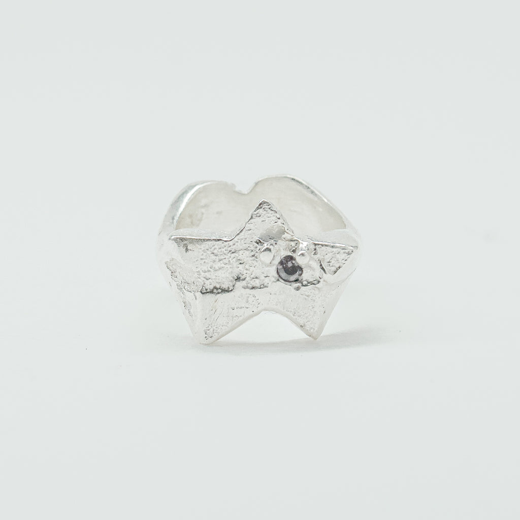 Sculptural silver ring showcasing both a heart and star form, with small gemstones set into each motif. Handmade and one of a kind.