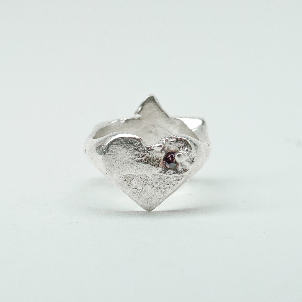 Sculptural silver ring showcasing both a heart and star form, with small gemstones set into each motif. Handmade and one of a kind.