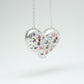 Bulbous heart-shaped sterling silver pendant, hand-sculpted with drilled textures and encrusted with small scattered gemstones. Playful and raw, with a cartoon-like silhouette.