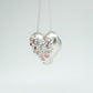 Bulbous heart-shaped sterling silver pendant, hand-sculpted with drilled textures and encrusted with small scattered gemstones. Playful and raw, with a cartoon-like silhouette.